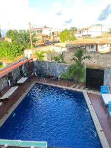 Una gran piscina azul en un patio. en Hôtel 2K, en Yaoundé
