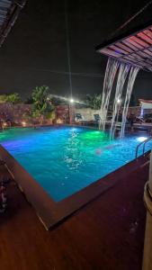 una piscina por la noche con una cascada en Hôtel 2K, en Yaoundé