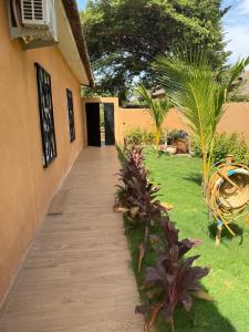 een loopbrug naar een huis met palmbomen bij Villa oasis, Résidence Nianing in Nianing