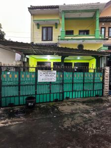 a green fence in front of a house at The wilsian - Syariah guest house in Sengkaling