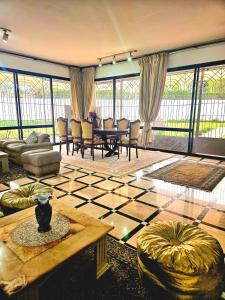 Oulad AkkouにあるVilla Luxury Suissi Rabatのテーブルと椅子のある広いリビングルーム