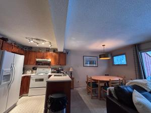 Horsethief Lodge by StayIn في بانوراما: مطبخ مع ثلاجة بيضاء وطاولة