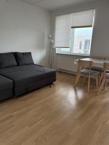 a living room with a couch and a dining room table at Odense Habor with access to the harbor sauna and pool in Odense