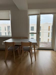 a table and chairs in a room with a large window at Odense Habor with access to the harbor sauna and pool in Odense