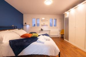 a bedroom with a large bed with blue walls at Modern 4-bed home Royal Wharf near Excel Canary Wharf London city airport The O2 -Free parking in North Woolwich
