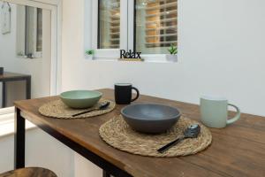 a wooden table with two bowls on top of it at Modern 4-bed home Royal Wharf near Excel Canary Wharf London city airport The O2 -Free parking in North Woolwich +92 photos
