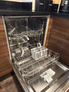 an empty dishwasher with two dishes in it at Modern 4-bed home Royal Wharf near Excel Canary Wharf London city airport The O2 -Free parking in North Woolwich