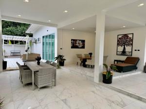 a large living room with a table and chairs at Beautiful villa between jungle in Ban Chong Phli