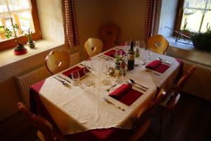 una mesa con mantel blanco y copas de vino en Agriturismo Ciablun, en La Valle