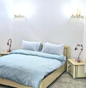 Oulad AkkouにあるVilla Luxury Suissi Rabatのベッドルーム1室(青いシーツとナイトスタンド付)