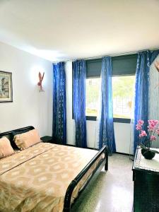 Oulad AkkouにあるVilla Luxury Suissi Rabatのベッドルーム1室(ベッド1台、青いカーテン、窓付)