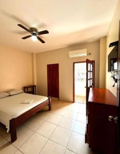 a bedroom with a bed and a ceiling fan at Hostal Luxury Place in Bahía de Caráquez