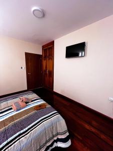 una camera da letto con un letto e una TV a schermo piatto di Estreno Suite en Loja, Valle a Loja
