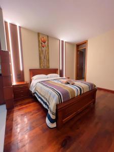 una camera da letto con un letto grande con pavimento in legno di Estreno Suite en Loja, Valle a Loja