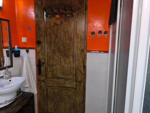 a bathroom with a wooden door and a sink at the monument's duplex bello in San Juan de Aznalfarache +61 photos