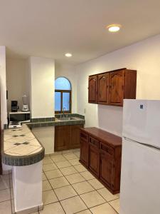 een keuken met houten kasten en een witte koelkast bij Departmento Ballena in Puerto Vallarta