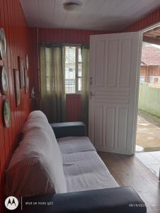 una cama en una habitación con una pared roja en Casa próximo ao Aeroporto, en Florianópolis