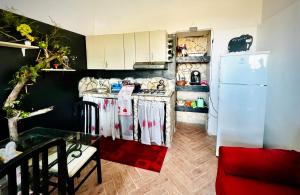 een keuken met een witte koelkast en een tafel bij Gli occhi del vulcano in Linera +12 foto's