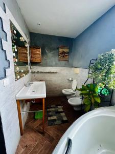 een badkamer met 2 toiletten, een wastafel en een bad bij Gli occhi del vulcano in Linera