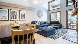 a living room with a blue couch and a table at Cloud 9 by AvantStay Located at the Base of Vail Ski Resort w Community Pool Hot Tub in Vail