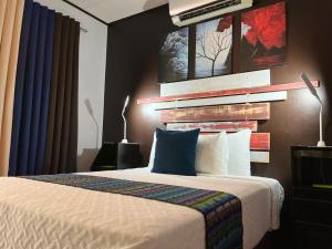 Un dormitorio con una cama y una pared con un cuadro. en Casa Olas, en Quepos