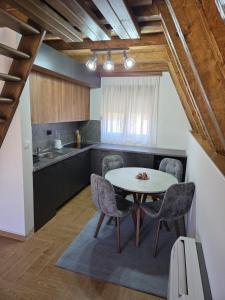 Monte Village في نيكشيتش: مطبخ مع طاولة وكراسي في الغرفة
