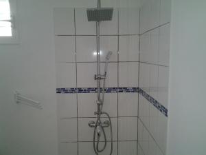 y baño con ducha y azulejos blancos. en Résidence PATROS, en Sainte-Anne 33 fotos más