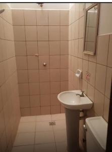 a bathroom with a sink and a toilet and a mirror at Hostal FINI in Trinidad