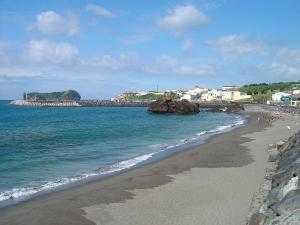 a beach with people walking on the sand and the water at Casa da Boa Ventura in Vila Franca do Campo