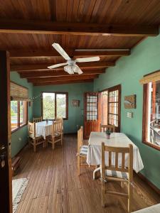 a dining room with two tables and a ceiling fan at Hostería Isabel in Las Grutas