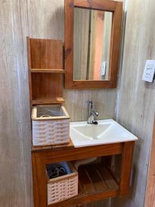 een badkamer met een wastafel, een spiegel en manden bij Quinta El Oasis in Junín