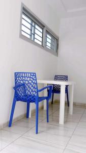 Appartement 3 pièces Tout Confort Calme - Colibri في ياموسوكرو: طاولة وكرسي أزرق وطاولة ومقعد أبيض +5 صور