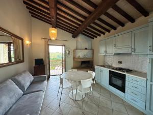 een keuken en woonkamer met een tafel en een bank bij Villa Mario & Friends in Pozzo