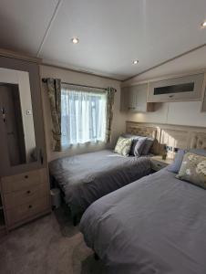 Giường trong phòng chung tại ABI Beaumont Luxury Caravan, Steps from Durdle Door