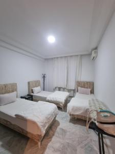 two beds in a room with white walls at Appartement de luxe lac 2 in Tunis