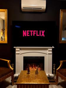 een woonkamer met een open haard en een tv erboven bij UNIQUE CBD BOTIQUE STAY, BALCONY,NETFLIX,FREE WIFI,FREE Tram,FREE Bus,Walk to Rundle St, UniAdelaide, RAH, Casino, Pubs, Cafes in Adelaide