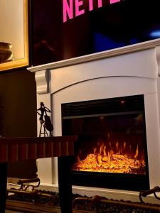 een open haard met een vuur erin bij UNIQUE CBD BOTIQUE STAY, BALCONY,NETFLIX,FREE WIFI,FREE Tram,FREE Bus,Walk to Rundle St, UniAdelaide, RAH, Casino, Pubs, Cafes in Adelaide