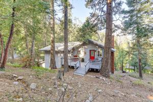 uma pequena casa na floresta com uma porta vermelha em Quiet Home Less Than 1 Mi to Lake Gregory and Dtwn Crestline em Arrowhead Highlands