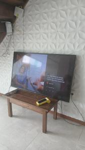 a tv sitting on top of a wooden table at Quartos em Arraial do Cabo in Arraial do Cabo