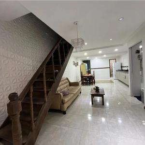 a living room with a staircase with a couch and a table at Quartos em Arraial do Cabo in Arraial do Cabo