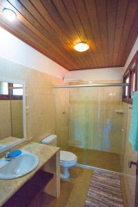 a bathroom with a shower and a toilet and a sink at Casa Edy in Praia do Forte