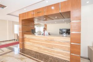a man standing behind a counter in an office at Super Hotel O Ivy Dew Drops in Bangalore +27 photos