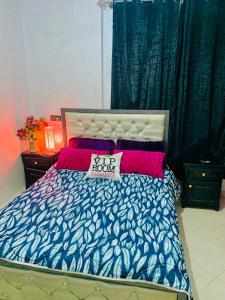 ein Schlafzimmer mit einem Bett mit einer blau-weißen Bettdecke in der Unterkunft Appartement Calme près du Stade Tamensourt in Oulad Akkou