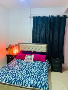 ein Schlafzimmer mit einem Bett mit einem Schild drauf in der Unterkunft Appartement Calme près du Stade Tamensourt in Oulad Akkou