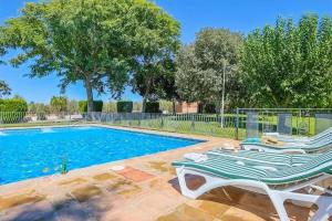 ein Pool mit zwei Liegestühlen daneben in der Unterkunft La Naranja Dulce CASA RURAL in La Carlota