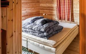 a bed in a room with a wooden wall at Awesome Home In Tjørhom in Haugen
