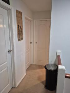 an empty hallway with a door and a trash can at The Garden view Nook in Ash +6 photos