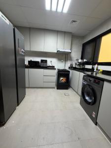 a kitchen with a washer and a stove in it at Sh vellage in Sharjah