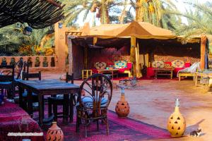 Un grupo de mesas y sillas en una tienda de campaña. en Auberge la Palmeraie, en Mhamid 44 fotos más