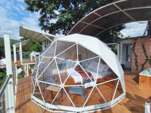 a white igloo on a deck of a house at Glamping Guacharaca Silvanía Cundinamarca in Silvania